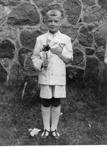 1958 metai. Rimantas Vanagas Pirmosios komunijos dieną Anykščių šventoriuje. Asmeninio archyvo nuotrauka